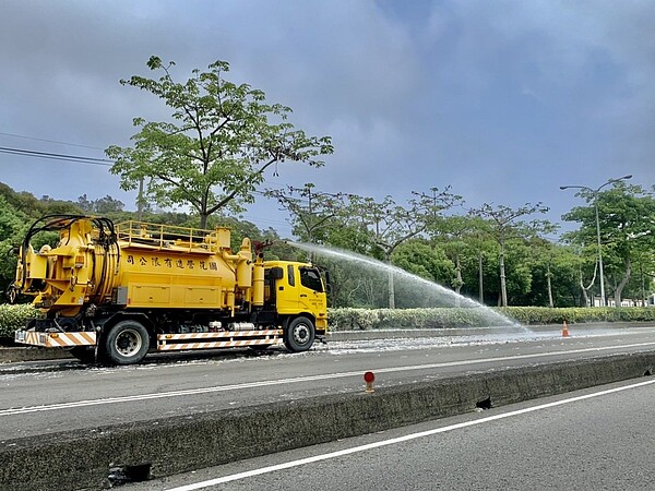 台中市台灣大道上， 靜宜大學到弘光科大之間的木棉樹，落花遭輾壓後影響交安，需以水柱清除。記者游振昇／攝影