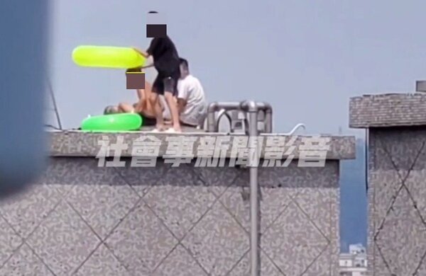 新北市三重區昨天（30日）有3個男童跑到社區大樓頂層陽台，把水塔當成游泳池，帶著泳圈去戲水。圖／取自社會事新聞影音