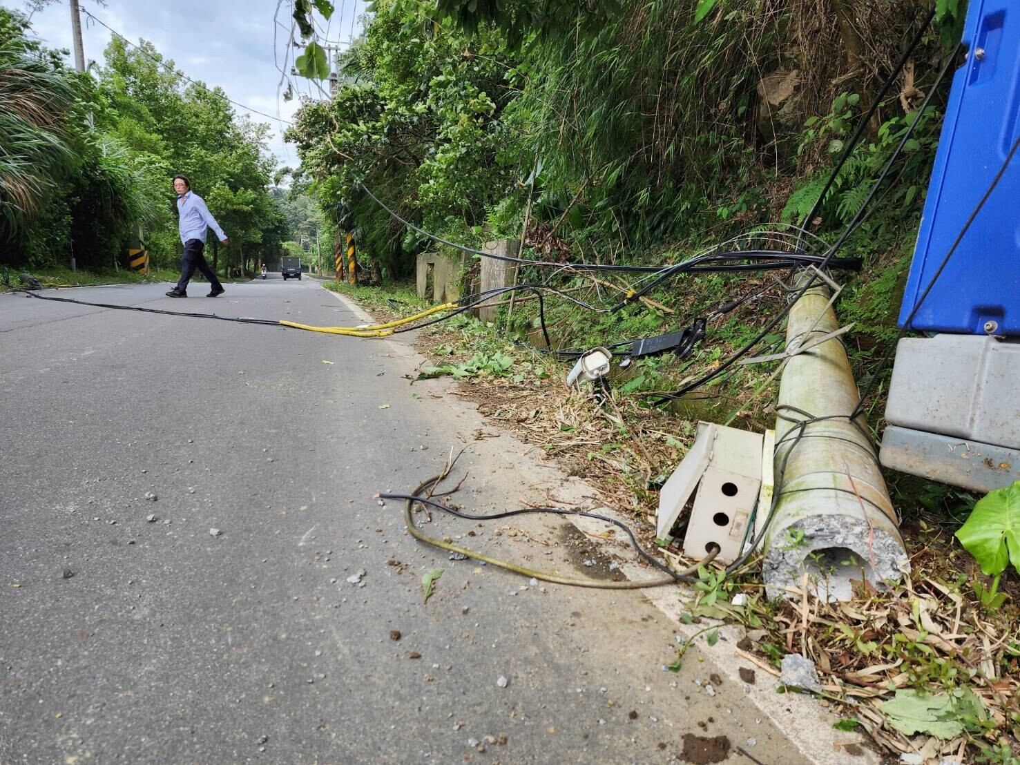 三峽區鳶山堰旁今下午工程車在此產業道路經過不慎扯斷中華電信電桿，影響當地兩百戶民眾網路及電話通信。記者李定宇／攝影 