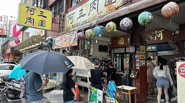 彰化今天上午下雨，但排隊名店「阿三肉圓」營業時間還沒到，就有民眾撐傘排隊。記者劉明岩／攝影
