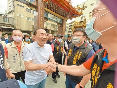 國民黨總統參選人侯友宜（左）10日到台中市中區輔順將軍廟參拜，與民眾互動親切。（張妍溱攝）