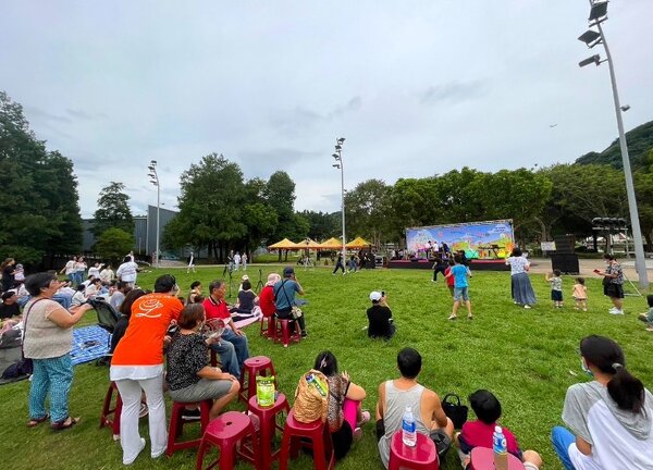 台北市內湖區紫雲里舉行「2023草地音樂節，讓爸爸開心」活動，許多家長帶著孩子一同坐在草地上，享受美妙的音樂，共度愉快的親子時光。圖／永慶房屋提供