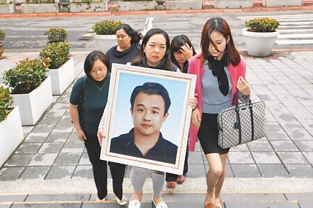 
遇害刑警薛貞國的妻子（中）2014年捧著遺照出庭討公道。（本報資料照片）
