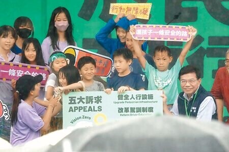 
行人零死亡推動聯盟20日在凱道舉行820還路於民大遊行，親子共學團體成員現場帶著小朋友，一起向交通部長王國材（右）傳達活動五大訴求。（鄭任南攝）
