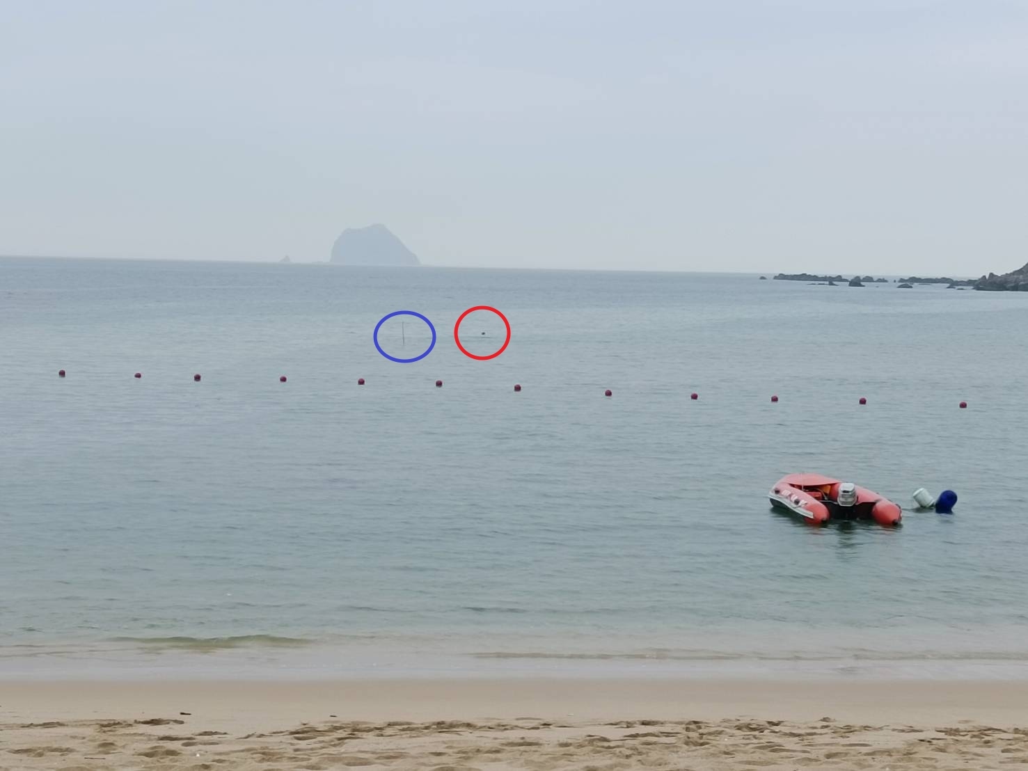 基隆市長謝國樑今到大武崙沙灘了解安全維護作業，浮球串起的警戒線已從攔沙壩（藍圈處）往內移，救生艇則從海上浮球（紅圈處）處，內移到藍圈處待命。記者邱瑞杰／攝影 