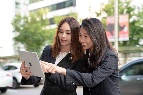 永慶房屋的「一對一師徒制」訓練,降低了轉職的不安全感,助劉姿妙(右)入行時有師父花菲(左)手把手指導。圖/永慶房產集團提供