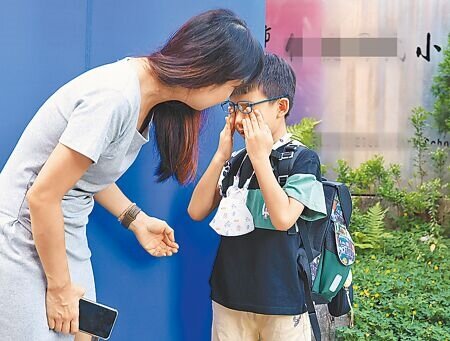 不少家長帶小朋友到校,在門口時捨不得分開。(陳俊吉攝)