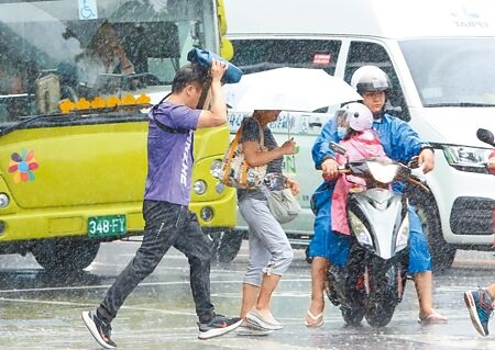 
中度颱風海葵1日晚間發布海上颱風警報，台灣北部在颱風外圍環流影響下已經有間歇性雨勢，民眾紛紛拿起雨具避雨。（鄭任南攝）
