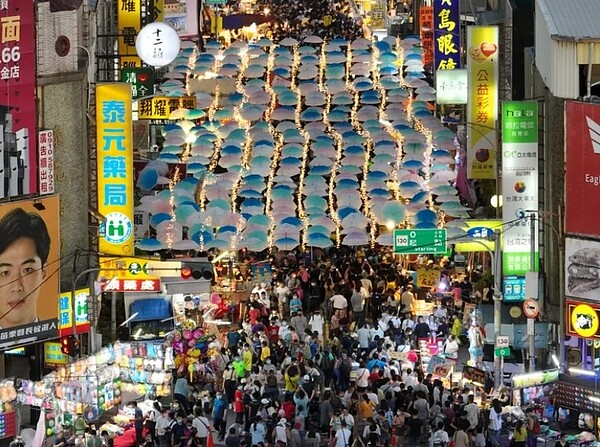 去年苑裡火車站前的鬼門關夜市設置馬卡龍漂浮傘、冰條燈等藝術元素裝置，一度成為網美朝聖景點，今年公所持續辦理。圖／張麥斯提供
