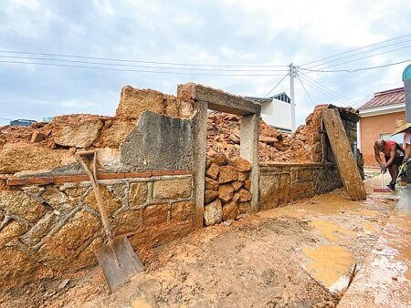 金門縣定百年古蹟東村「雙喜樓」不敵暴雨侵襲,6日上午牆面應聲崩塌,文化局緊急找來工人清理善後,目前僅剩斷垣殘壁。(于家麒攝)
