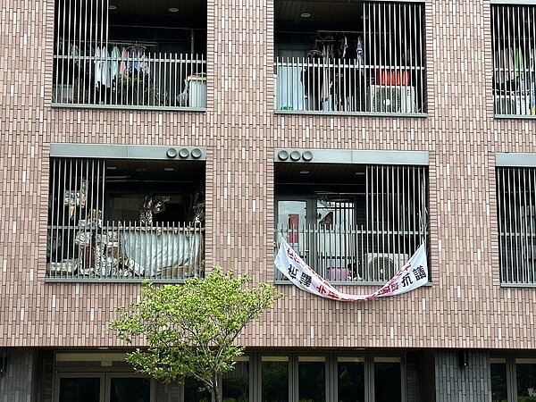 北市明倫社宅住戶拉布條抗議，指隔壁獨居長輩製造髒亂惡臭，已忍受3年。圖／議員陳怡君提供