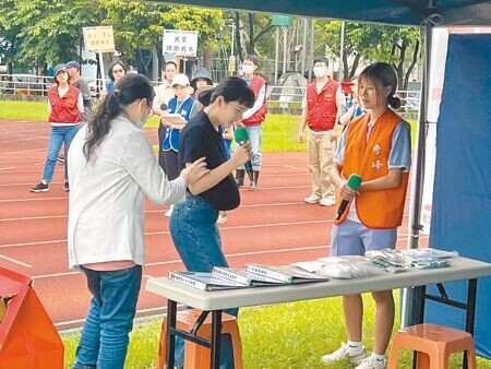 汐止區公所辦理「防災公園演練」，模擬情境逼真，在簡易醫療區有孕婦突然羊水破了，護理師安撫情緒並協助就醫。（王揚傑攝）