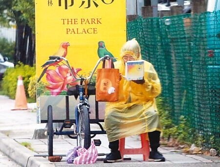 根據主計總處2022年調查,逾34萬名全時受僱勞工月收入未達2萬5000元,較當年2萬5250元基本工資還低,但僅有227件挨罰。圖為廣告舉牌員工路邊吃飯。(本報資料照片)