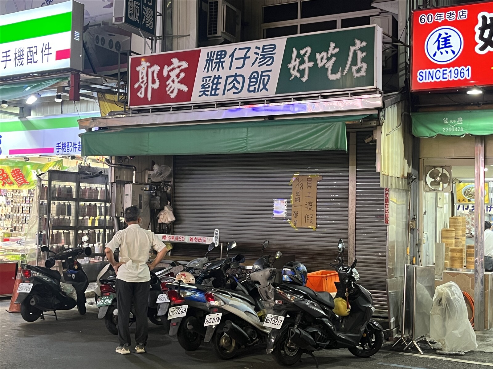 嘉義市文化路夜市知名店家「郭家雞肉飯」拉下鐵門貼公告「員工渡假」，要到下周一（18日）才營業。路過民眾好奇觀看。記者李宗祐／攝影 