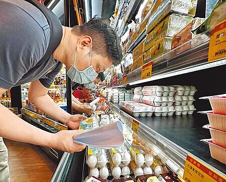 農業部進口蛋爭議爆不停,圖為民眾在超市選購時仔細查看產地來源。(陳怡誠攝)