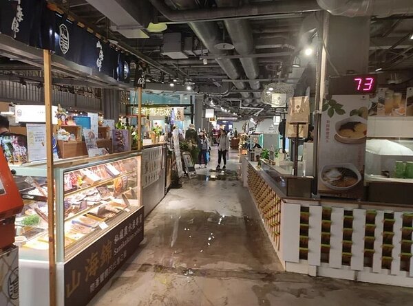 高雄昨晚下大雨,棧貳庫商場內部的冷氣管道因排水不及,造成漏水,商家一起清理積水。圖/讀者提供
