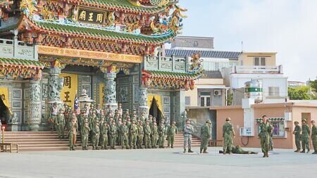 一早出門行軍回來的召員在廟前合影紀念。(許逸民攝)