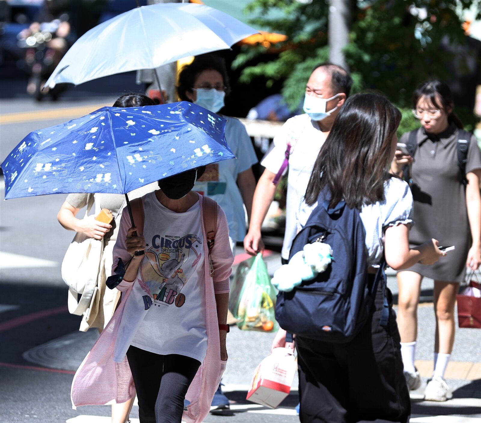 近日白天晴朗炎熱,很有夏季的感覺,圖為昨天民眾紛紛撐起陽傘遮陽。記者侯永全/攝影