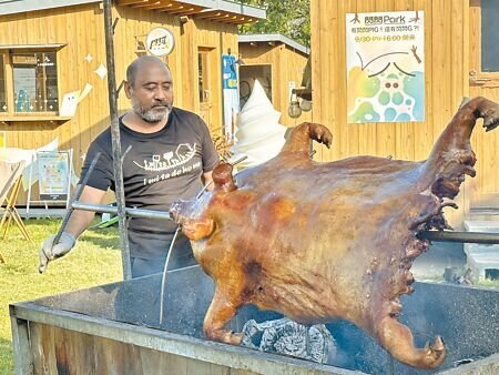 台東閃閃Park昨天推出1隻約百斤的烤全豬,還是帶有獠牙的山豬,負責烤肉的布農勇士說,要把最新鮮的好滋味帶給遊客品嘗。(蔡旻妤攝)