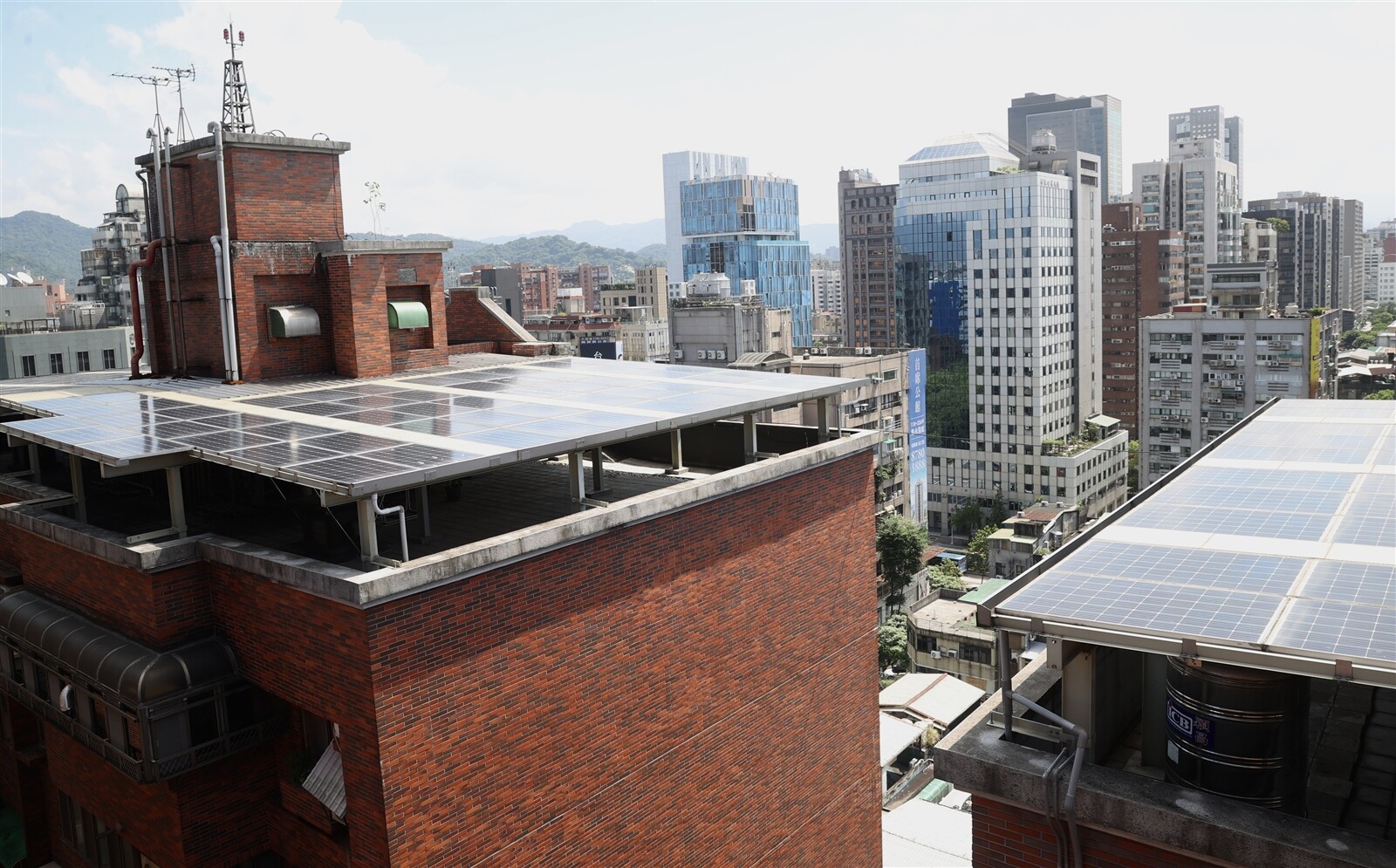 台北市府為了拚綠電、減碳，決定有條件放寬違建屋頂設光電板，也向內政部爭取降低屋頂種電的住戶同意門檻，引發環境衝擊的討論；圖為北市信義新城頂樓合法設光電板、創造收入情形。記者林俊良／攝影 