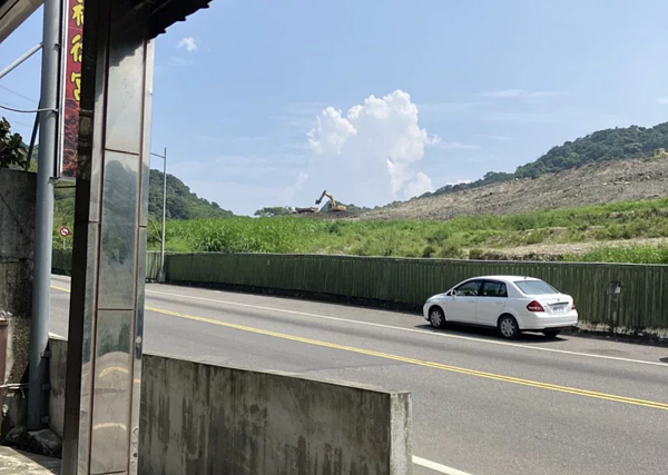 新北市萬里區中福路旁有處土石方收容場堆置大量土石，附近居民抱怨造成揚塵汙染，更擔心下雨會有泥流危害。圖／新北市議員張錦豪提供