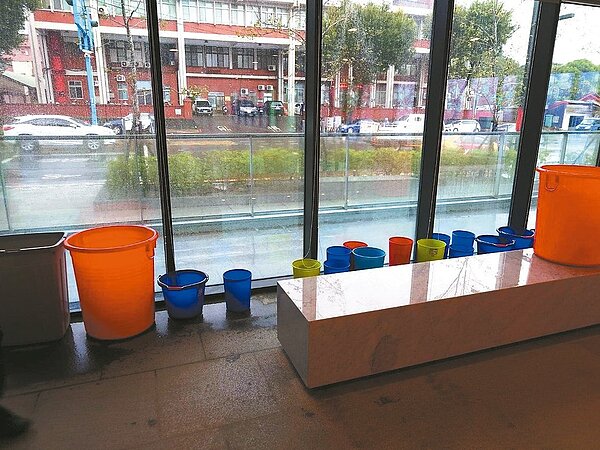 桃園楊梅區公所挺過上浮問題,前天遇雨後室內3處區域開始出現漏水,公所趕緊擺放水桶因應。圖/市議員周玉琴提供