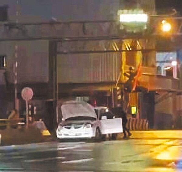 林姓老翁駕駛汽車行經蘇澳高級海事水產職業學校前平交道，突然熄火卡在柵欄下方，2名學生見狀，緊急翻越學校圍牆救援。（民眾洪方生提供／吳佩蓉宜蘭傳真）