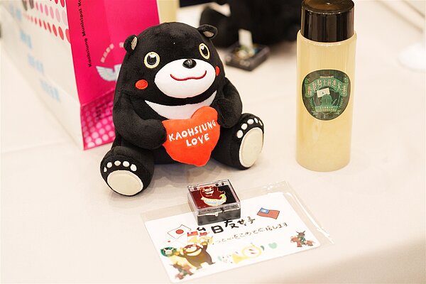 翡翠騎士在高雄演出引起熱烈迴響,高市府特別舉辦「台日四校交流應援派對」,致贈日本學生高雄熊玩偶及別針、高雄青年設計限量明信片;印有翡翠騎士隊徽的割包、以及「高字徽」的翻糖蛋糕大受學生歡迎。圖/新聞處提供