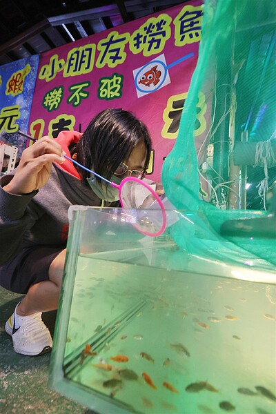 動保法修正草案遭撈金魚攤商反彈後,農委會改口「暫不納入水族類」;圖為新北夜市的撈金魚遊戲。記者陳正興/攝影