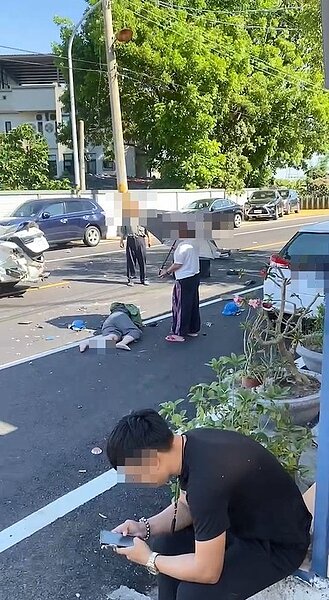 高雄3名婦人遭陳姓士官駕車衝撞,當下倒地昏迷,躺在柏油路上,附近民眾幫忙撐傘,肇事的陳姓士官蹲在路旁抽菸、滑手機,讓看到畫面的人,拳頭都硬了。記者石秀華/翻攝