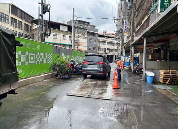 中和區立德街26巷5弄路面有坑洞及隆起狀況,經調查是一旁科技大樓基地內灌漿工作導致,市府已經要求暫停施工。圖/新北工務局提供