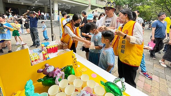 永慶房屋在攤位上發送飲料、小點心,為校慶增添歡樂氣氛,讓學生與家長享受園遊會。圖/永慶房屋提供
