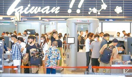 因應日本G7高峰會期間航空保安需求,桃園機場14日起針對飛往日本航班(包括轉機)旅客加強安檢。在桃園機場出境管制區內,旅客正在排隊安檢。(范揚光攝)