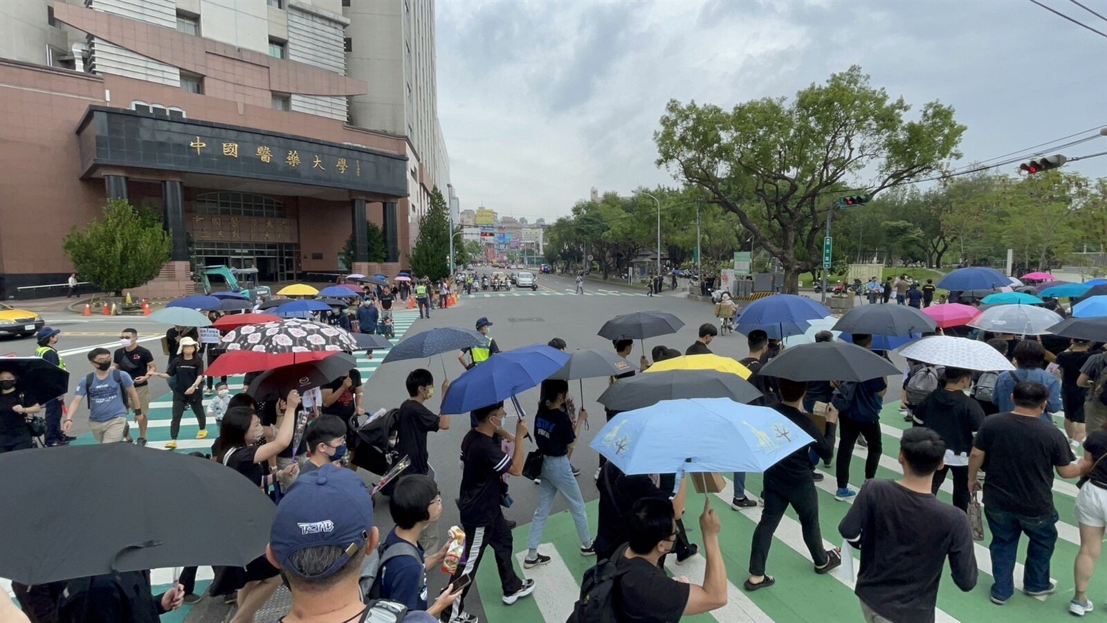 「行人安全大富翁 全台行人罹難路口串聯」快閃活動,台中場在台中市英才與學士路口舉辦,百餘民眾身著黑衣、打雨傘、手持康乃馨。在路口繞行,表達對路口不安全的憤怒。記者黃寅/攝影