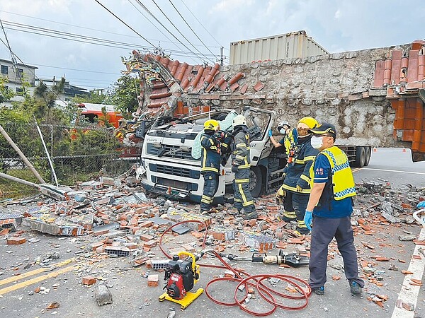 南投市南營路慶福寺牌樓遭貨櫃車衝撞，十幾噸重的水泥牌樓斷裂直接壓倒在貨櫃車車頭，南投縣消防局獲報出動吊車前往救援。（南投縣議員林儒暘提供／馮惠宜南投傳真）