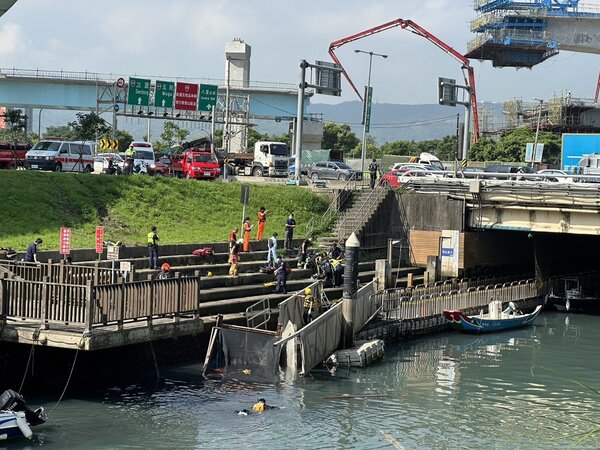 砂石車衝破台北港護城河欄杆墜入河內。圖／新北消防局提供