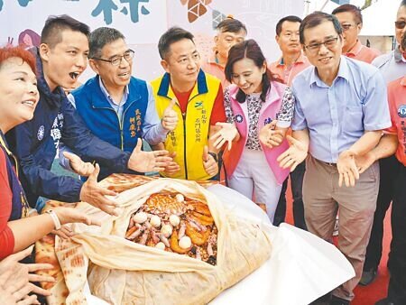 新北市石門區公所27日舉行「新北第一粽」活動,推廣在地農特產,現場百斤大肉粽,吸引民眾搶拍嘗鮮。(蔡雯如攝)