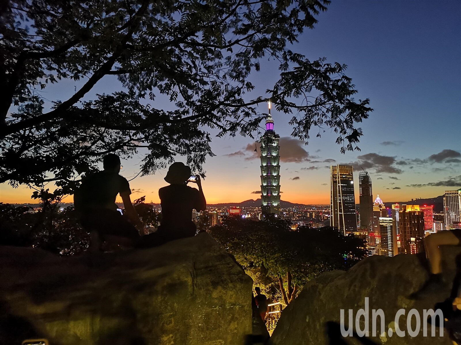 瑪娃颱風減弱北轉，台北傍晚出現颱風來臨前的景象，橘紅的夕陽吸引許多人到象山拍照。記者邱德祥／攝影 