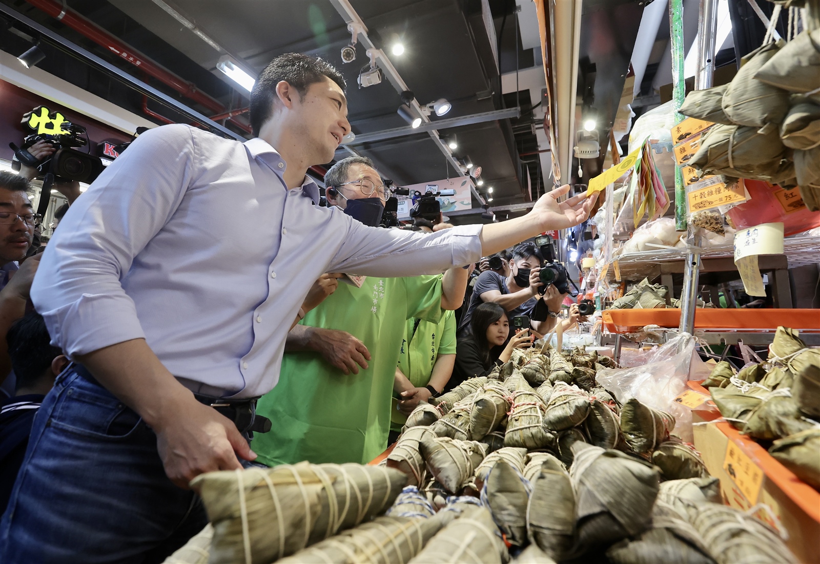 台北市南門市場回原址前最後一次舉辦「百粽宴」，市長蔣萬安（左）昨天大啖各式粽子，推廣南門市場各家粽子名攤。記者許正宏／攝影 