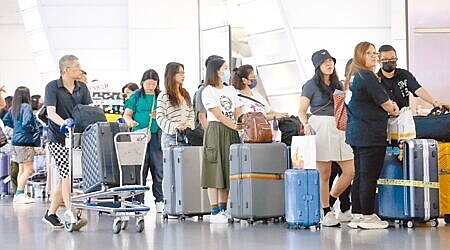 旅行業者指控,契約責任險條文日前被保險公司片面修改,恐將損害旅客權益。16日在桃園機場第一航廈出境大廳內,旅客正在排隊辦理報到手續。(范揚光攝)