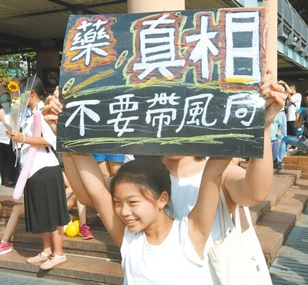 
多個團體18日在新北市政府市民廣場舉辦「不藥傷害我的孩子」活動，家長帶著孩子高舉「藥」真相、不要帶風向的牌子。（陳君瑋攝）
