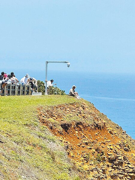 雙心石滬觀景區有遊客冒險翻出圍欄外取景,其他遊客跟著仿效。圖/民眾提供