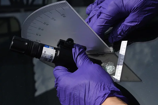 警方鑑識小組運用雷射筆實施彈道重建及分析彈著點,研判是以空氣槍裝填鋼珠彈從高處射擊擋風玻璃所致。圖/警方提供