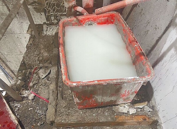 台中市環保局查獲大里區德芳南路一處工地清洗披土桶槽,所產生之廢水未有效收集處理,直接排入側邊水溝,廢水沿溝渠流入大里運動公園旁大排。圖/台中市議員江和樹提供