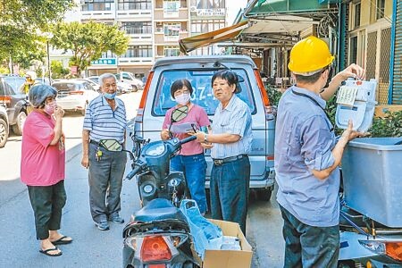 住竹北市三民路的黃姓民眾（右二）申裝微電腦瓦斯表，向鄰居說每月多40元，住家有保障划得來。（羅浚濱攝）
