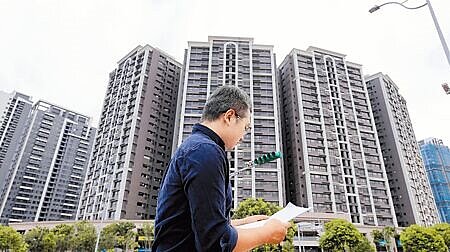 《房屋稅條例》修正案三讀後,近50萬戶多屋族持有成本將大增,特別是餘屋量龐大的建商首當其衝,業者勢必將成本反應在售價上。圖為年輕民眾在桃園市龜山A7重劃區了解房地產相關資訊。(本報資料照片)