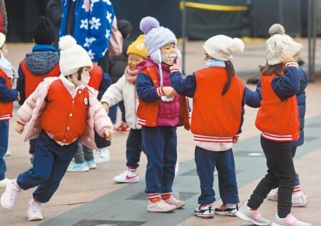 寒流來襲全台急凍，小朋友22日身穿厚外套加帽子，在寒風中玩耍。（張鎧乙攝）