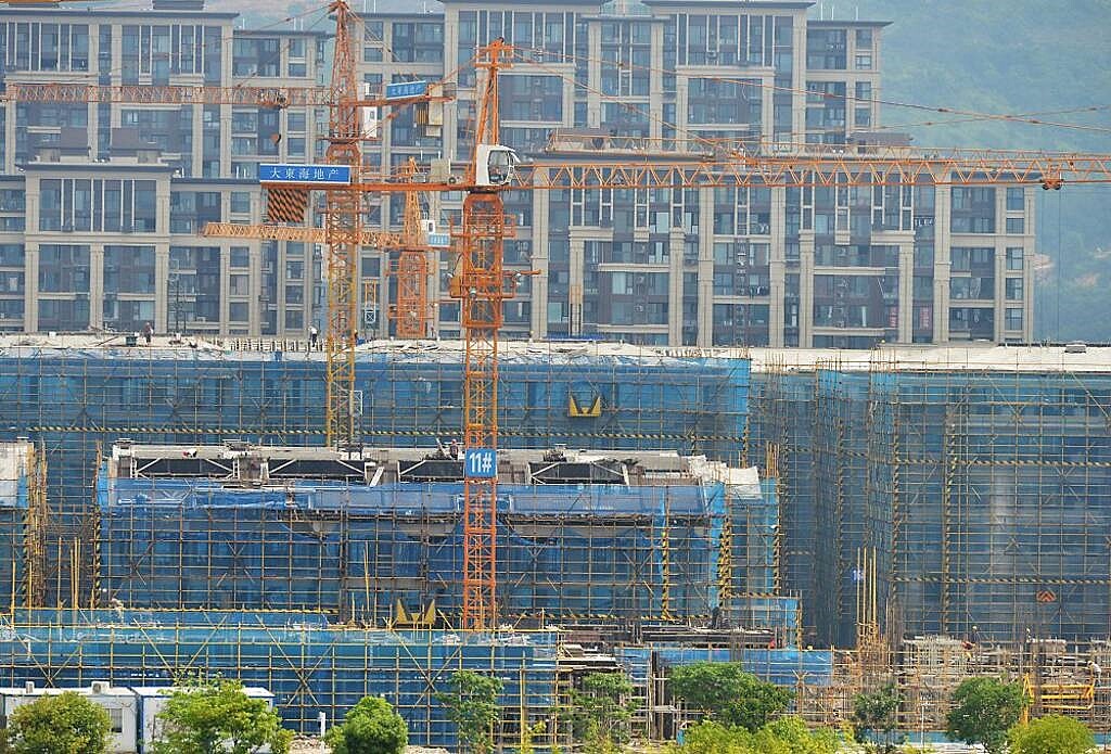 今年以來大陸債券市場違約規模創5年新低,從違約行業來看,房地產企業仍是違約大戶。圖/中新社