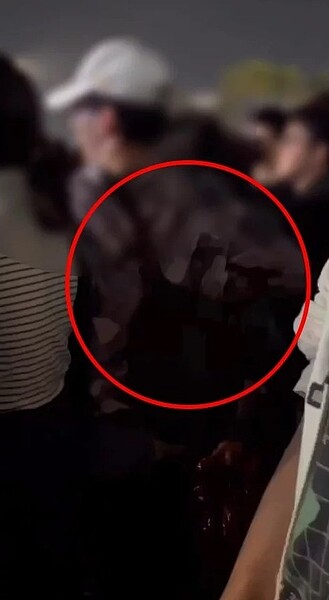 高雄市前鎮警分局警方今天下午公布高雄跨年晚會目擊者拍下白帽男子和前方男子口角，掏出原子筆影像。圖／記者石秀華翻攝
