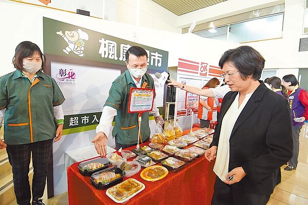 彰化縣政府2日宣布將2011年起推動的幸福餐券再升級,學童只要持彰化縣數位學生證至便利商店或超市就可以領取餐點,彰化縣長王惠美(右)關心超商提供的便當菜色。(彰化縣政府提供/孫英哲彰化傳真)